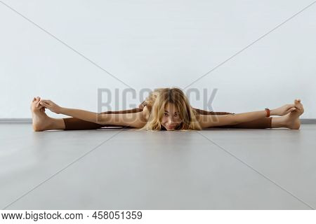 Young Attractive Fitness Woman Performing Twine , Upavista Konasana