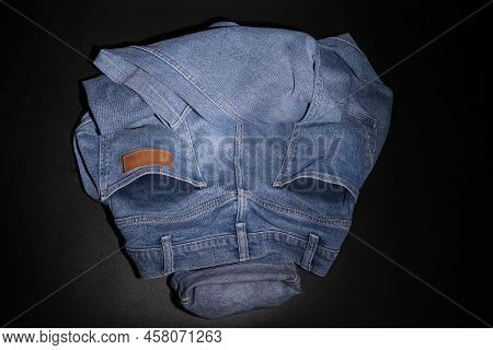 Alian's Face Is Made From Folded Blue Jeans On A Black Background.