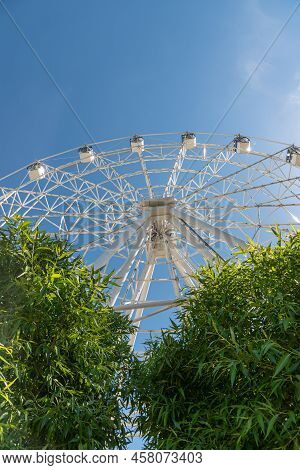 Ferris Wheel With White Covered Booths. The Attraction Is To Ride In A Circle. Part Of The Ferris Wh