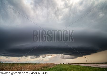 A Flying Saucer Shaped Supercell Thunderstorm Hovers In The Sky Over A Highway In Rural Nebraska.