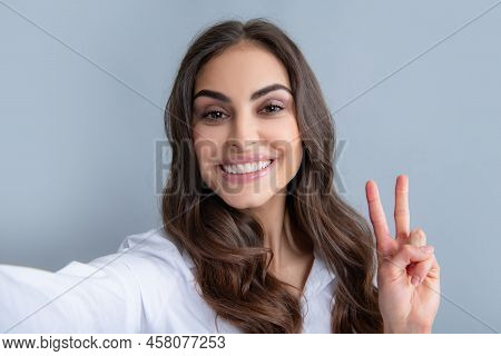 Portrait Of Cheerful Smiling Woman Having Video-call, Shooting Selfie. Young Girl In White Shirt Wit