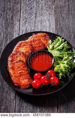 Grilled Slices Of Pork Loin Marinated In Paprika Based Sauce With Fresh Tomatoes And Lettuce Leaves 