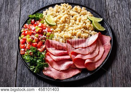 Thinly Sliced Roast Beef Fillet With Quinoa And Tomato Pepper Salsa On Black Plate On Dark Wooden Ta