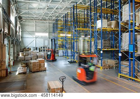 Interior Of A Modern Warehouse Storage Of Retail Shop With Pallet Truck Near Shelves