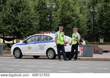 Moscow, Russia - July 2022: Two Traffic Police Officers Standing On The Road Near Their Car. Policem