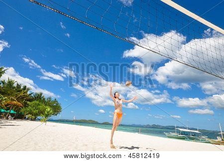 one bikini girl playing volleyball on white beach