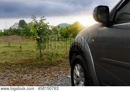 Beside Of Front Car With Drop On Water On The Car. Car Gray Color. Front Side With Nautre Of Graden 