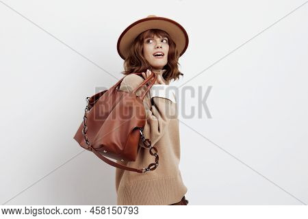 A Delightful Woman Poses In Height Standing Sideways On A White Background In A Sweater, Shirt And H