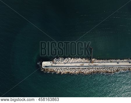 Aerial Drone View Of A Breakwater. Tetrapod Pier Along The Shore, Sea Waves Breaking On Tetrapod Pie