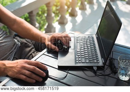 Working At A Laptop In The Outdoor Courtyard - Men\'s Hands Close-up. Home Office, Remote Work, Remo