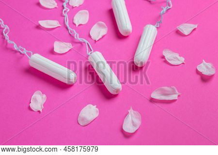 Female Tampons With With Cherry Petals On A Pink Background. Hygienic White Tampon For Women. Cotton