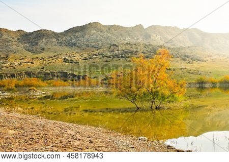 Mravaltskaro Reservoir In Autumn With Tent And White Desert Canyons In Background. Georgia Travel De