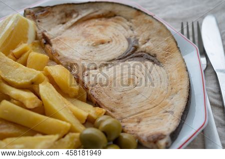 Seafood Dish, Grilled Steak From Swordfish Or Spada Served With French Fried Potatoes And Green Oliv