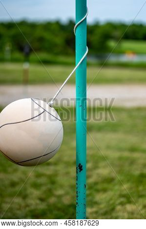 Tetherball Sitting Idle Next To The Pole In A Backyard.