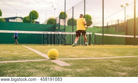 Professional Monitor Of Padel Jump To The Ball With A Black Racket. Sport Game