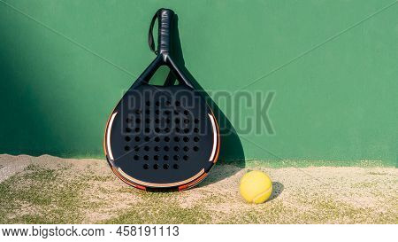Yellow Ball On Floor Near Of Padel Tennis Racket In Green Court Outdoors