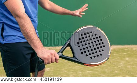 Monitor Practicing Paddle Sport With A Black Padel Racket On A Green Court Grass