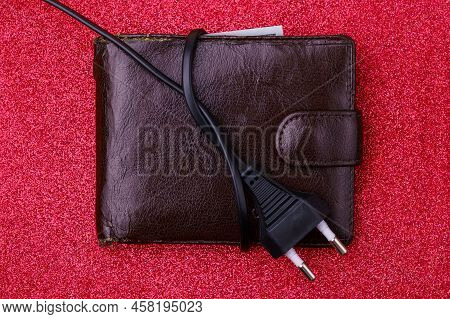 An Electrical Wire Tied Into A Knot On An Old Decrepit Wallet. The Concept Of The Energy Crisis And 