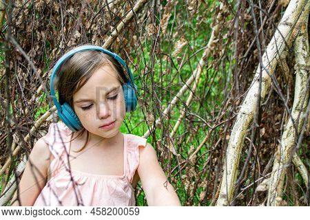 Girl Around With A Branch And Wearing Headphones