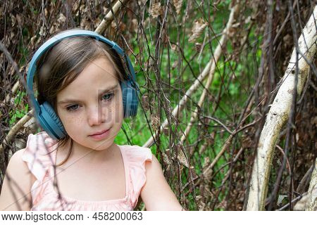 Girl Around With A Branch And Wearing Headphones