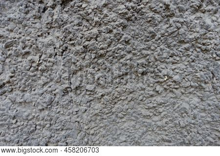 Uneven Surface Of Dusty Wall With Coarse Dark Gray Roughcast Finish