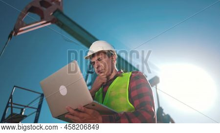 Oil Industry. Engineer Next To An Oil Rig. Oil Production Business Finance Concept Sun. Gas Producti