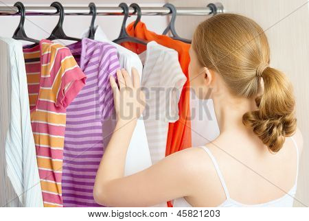 ผู้หญิงเลือกเสื้อผ้าในตู้เสื้อผ้าที่บ้าน