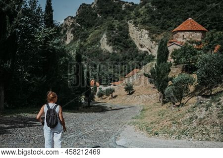 Senior Traveling Woman Backpacker Tourist Outdoors In Ancient Europe Fortress Monastery Shio-mgvime 