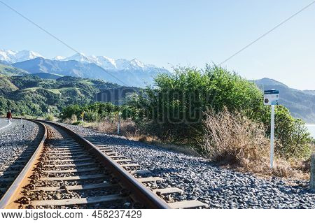 Kaikoura New Zealand - May 11 2022; Rusty Rail Tracks Running Along Kaikoura Coast With Man Walking 