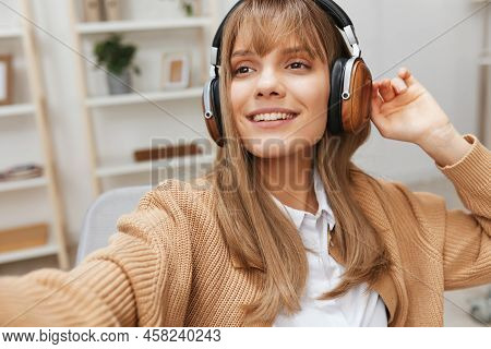 Smiling Young Blonde Student Lady In Warm Sweater In Headphones Listen Fav Songs Look Aside Sitting 