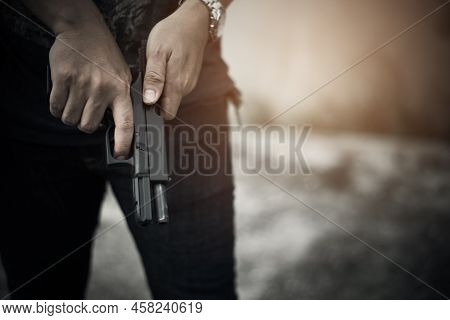 Robber Holding Gun For Ready To Murder Steal Moneys At Abandoned Building. Selective Focus. Criminal