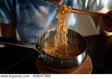 Woman Eating Instant Noodles In Aluminum Pot