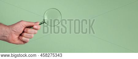 Magnifying Lens Glass In Hand On Green Banner With Copy Space For Text.