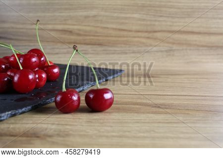 Cherries On A Black Tray On The Table. Ripe Berry Close-up. Growing Cherry Berries Healthy Eating He