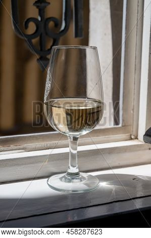 Tasting Of White Grand Cru Classe Chablis Wine With Old French Houses On Background, Burgundy, Franc
