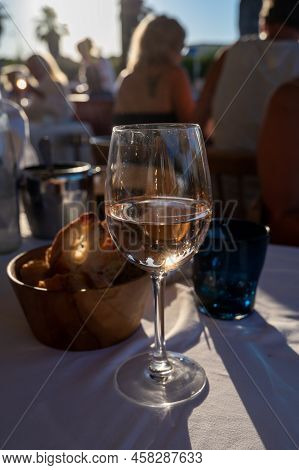 Dinner At Sunset In French Restaurant With Cold Dry Rose Wine In Port Grimaud, Summer Vacation On Fr