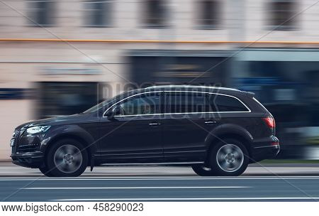 Moscow, Russia - July 2022: Side View Rolling Shot With Brown Crossover Car In Motion. Audi Q7 Drivi
