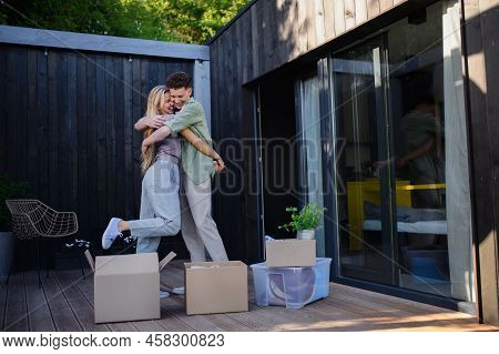 Cheerful Young Couple Moving In Their New Tiny House In Woods. Conception Of Moving And Sustainable 