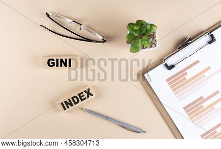 Gini Index Text On A Wooden Block With Chart And Glasses, Business Concept