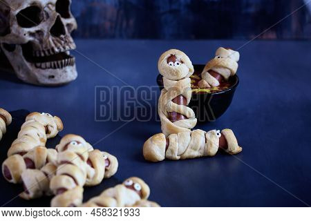 Fun Food For Kids. Mummy Hot Dogs (or Pigs In A Blanket) On A Blue Rustic Table With A Bowl Of Ketch