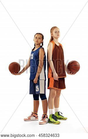 Portrait Of Two Young Girls, Basketball Players Posing With Basketball Ball Isolated On White Backgr