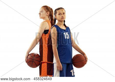 Portrait Of Two Young Girls, Basketball Players Posing With Basketball Ball Isolated On White Backgr