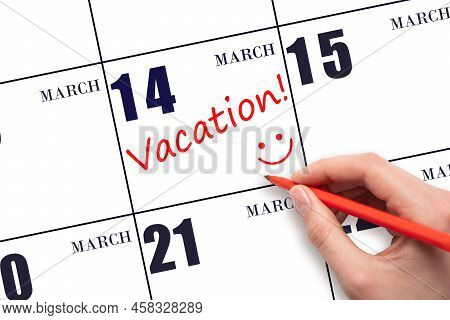 14th Day Of March. A Hand Writing A Vacation Text And Drawing A Smiling Face On A Calendar Date 14 M