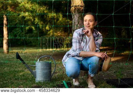 Charming Hispanic Woman, Farmer Relaxing During Planting Seedling In The Open Ground Of A Countrysid