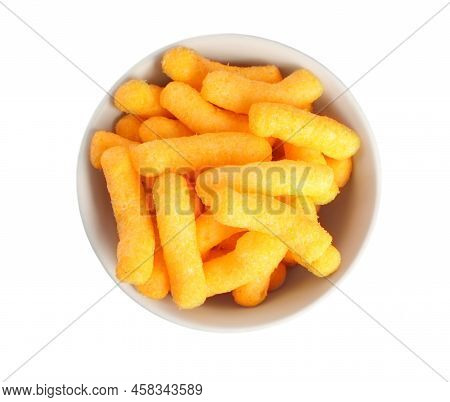 Many Tasty Cheesy Corn Puffs In Bowl Isolated On White, Top View