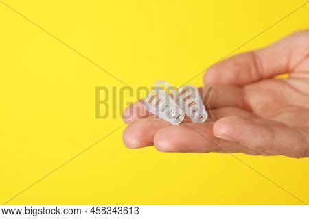 Woman Holding Anti-snoring Device On Yellow Background, Closeup. Space For Text
