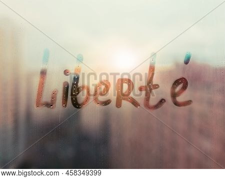 Hand Drawn French Word Liberte Freedom In English On Foggy Glass On Suset Window