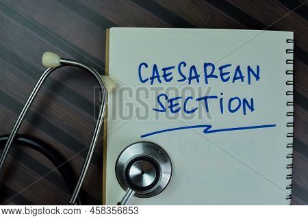 Concept Of Caesarean Section Write On A Book With Stethoscope Isolated On Wooden Table.