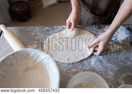 A Baker Shapes And Cuts Traditional French Fougasse Bread. Front View.