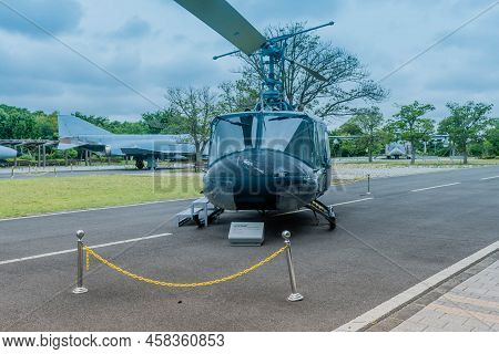 Jeju City, South Korea; June 20, 2022: Bell Uh-1b Helicopter On Pavement At Museum Under Cloudy Sky.